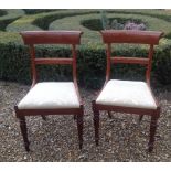 A PAIR OF REGENCY PERIOD MAHOGANY BAR BACK DINING CHAIRS With upholstered drop in seats and raised