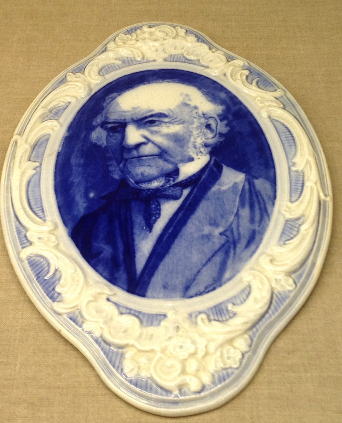 A LATE 19TH/EARLY 20TH CENTURY POTTERY WALL PLAQUE Portrait of Gladstone, in blue and white and