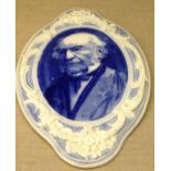 A LATE 19TH/EARLY 20TH CENTURY POTTERY WALL PLAQUE Portrait of Gladstone, in blue and white and