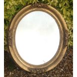 A 19TH CENTURY OVAL GILT FRAMED MIRROR Decorated with floral cartouches. (approx 59cm x 67cm)