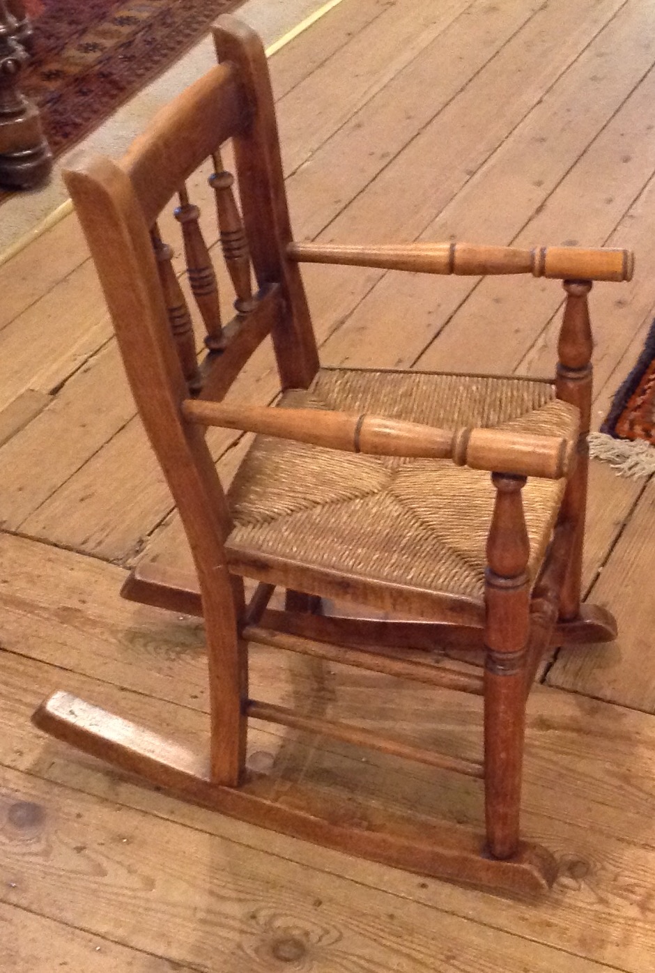 AN EARLY 20TH CENTURY CHILD'S BEECH WOOD ELBOW CHAIR Having a spindle back and rush seat. (approx - Image 2 of 2