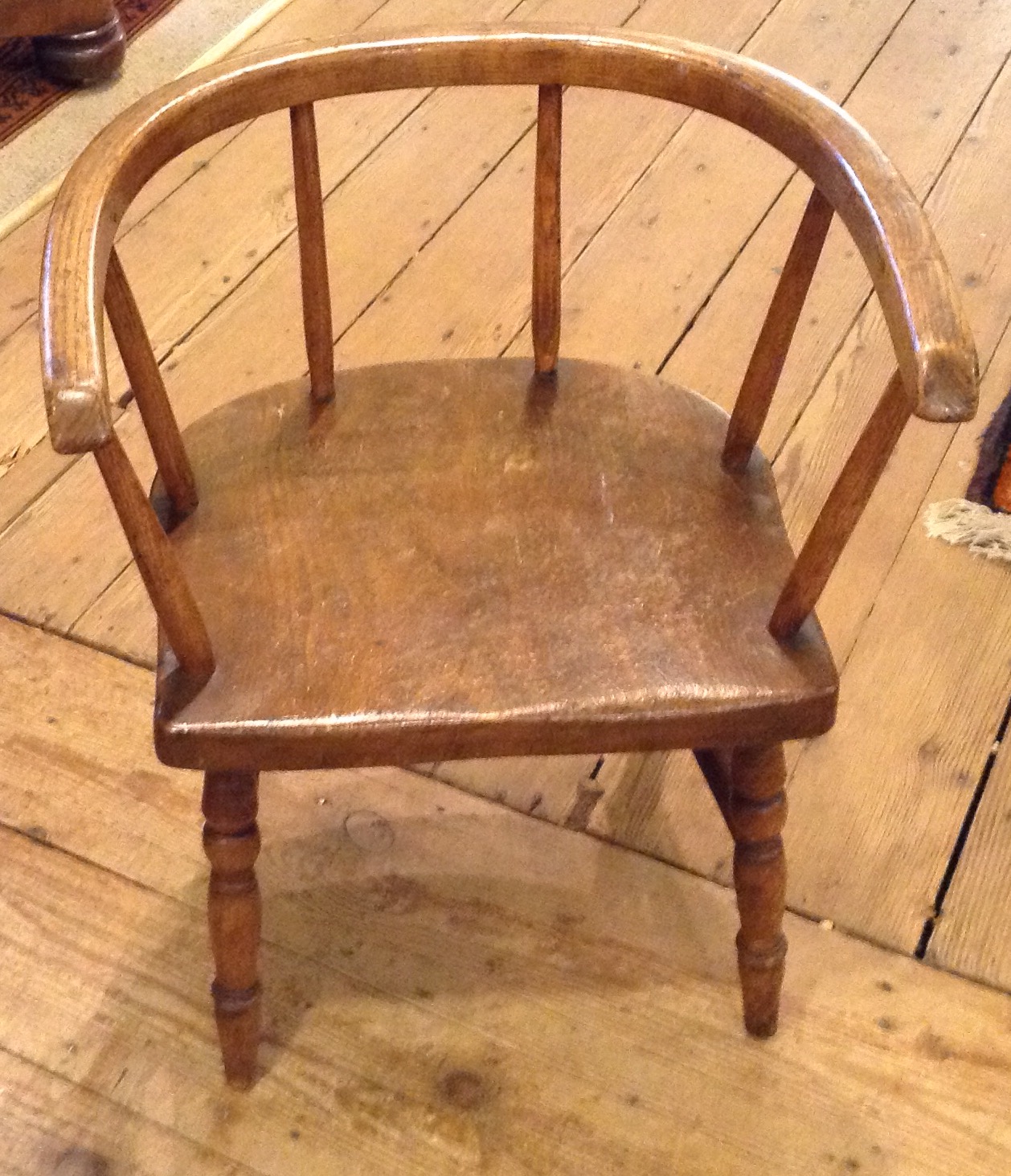 A LATE 19TH/EARLY 20TH CENTURY ELM AND ASH CHILD'S CHAIR Having a bow back and raised on turned