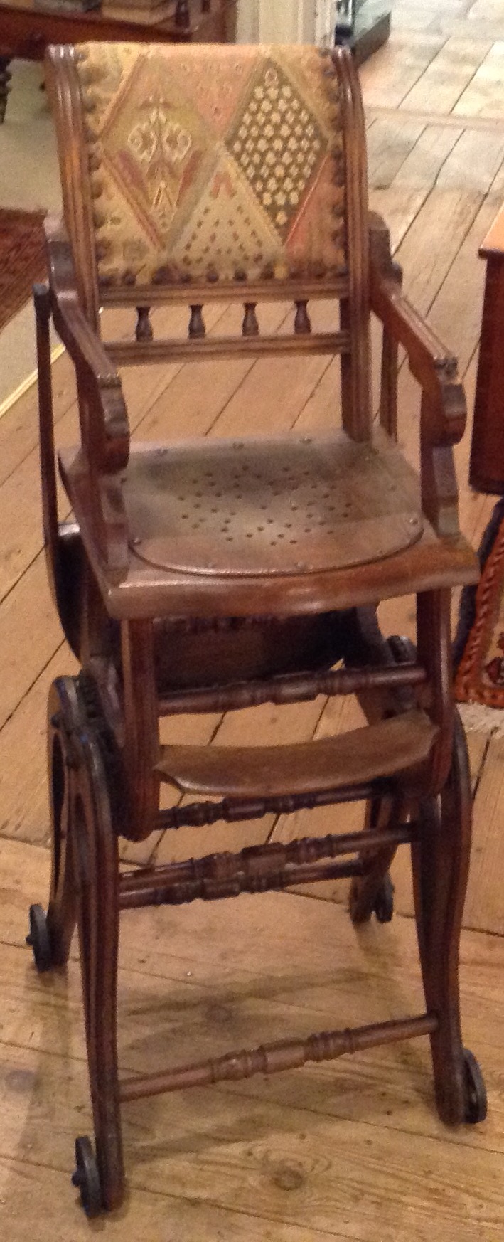 AN EDWARDIAN METAMORPHIC CHILD'S HIGH CHAIR Having beech wood on wheels and a decorative fabric - Image 2 of 2