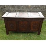 AN EARLY 18TH CENTURY OAK COFFER With three carved panels and raised on stile feet.