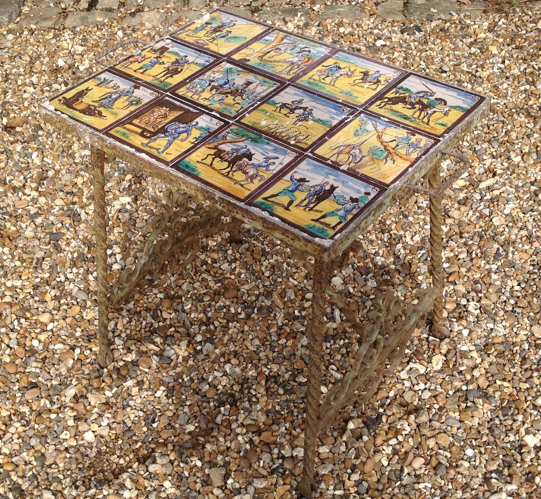 A 19TH CENTURY SIDE TABLEinset with various pictorial tiles, supported on a decorative wrought
