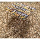 A 19TH CENTURY SIDE TABLEinset with various pictorial tiles, supported on a decorative wrought