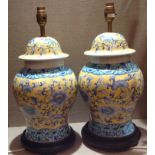 A PAIR OF CHINESE STYLE CERAMIC LAMPS Decorated with blue flowers and turquoise panels on yellow