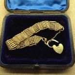 A VICTORIAN HALLMARKED 18CT GOLD GATE BRACELET Hung with a heart form locket, in velvet lined