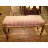 A 19TH CENTURY FRENCH DUET STOOL With overstuffed upholstered seat, above a floral cartouche and