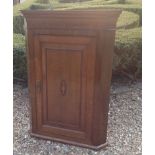 AN 18TH CENTURY MAHOGANY AND OAK WALL HANGING CORNER CABINET The deep cushion cornice above a single