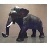 A 19TH CENTURY MEIJI PERIOD JAPANESE BRONZE ELEPHANT  With ivory tusks, in a walking pose and