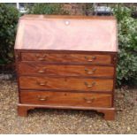 A GEORGIAN MAHOGANY FALL FRONT WRITING BUREAU Opening to reveal a fitted interior above four