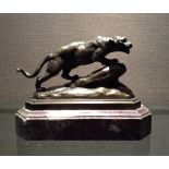 A 20TH CENTURY FRENCH BRONZE ART DECO LIONESS  Perched on a rock, raised on a stepped purple