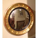 A 19TH CENTURY CIRCULAR CONVEX MIRROR Set in a deep cushion water gilt frame.