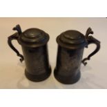 TWO EARLY 20TH CENTURY PEWTER LIDDED TANKARDS Having glass bottoms and inscribed 'Queen's College