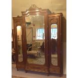 A LATE 19TH CENTURY FRENCH MAHOGANY BREAKFRONT TRIPLE WARDROBE  Having bevelled plate mirrored doors