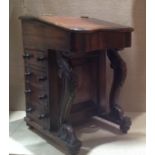 A MINIATURE OAK DAVENPORT DESK The tooled writing surface enclosing a fitted interior, above four