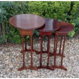 AN EARLY 20TH CENTURY MAHOGANY NEST OF THREE TABLES  Having circular dished tops and raised on