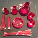 A 20TH CENTURY WHITEFRIARS GRADUATED SET OF RED GLASSWARE JUGS Having clear glass handles, along