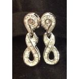 A PAIR OF 18CT WHITE GOLD AND DIAMOND SET EARRINGS  The channel set stud upper part holding a