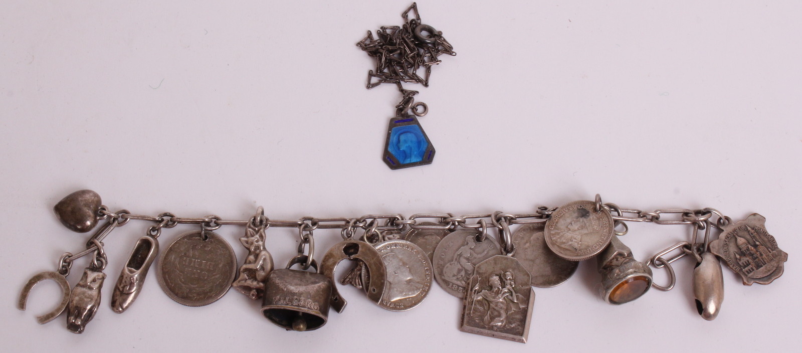 A SILVER CHARM BRACELET  Hung with eighteen charms, to include 20th Century coins, one being an 1852