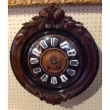 A 19TH CENTURY FRENCH CHIMING VINEYARD CLOCK  The circular mahogany case heavily carved with