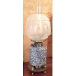 A 19TH CENTURY DUPLEX BLUE AND WHITE POTTERY AND BRASS OIL LAMP The pottery cylindrical well