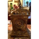 A LATE 19TH CENTURY BRASS CASED MANTEL CLOCK Mounted with a seated cherub above a silvered dial,