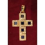 A SAPPHIRE AND DIAMOND SET YELLOW METAL CROSS PENDANT  Constructed of six squares, with the