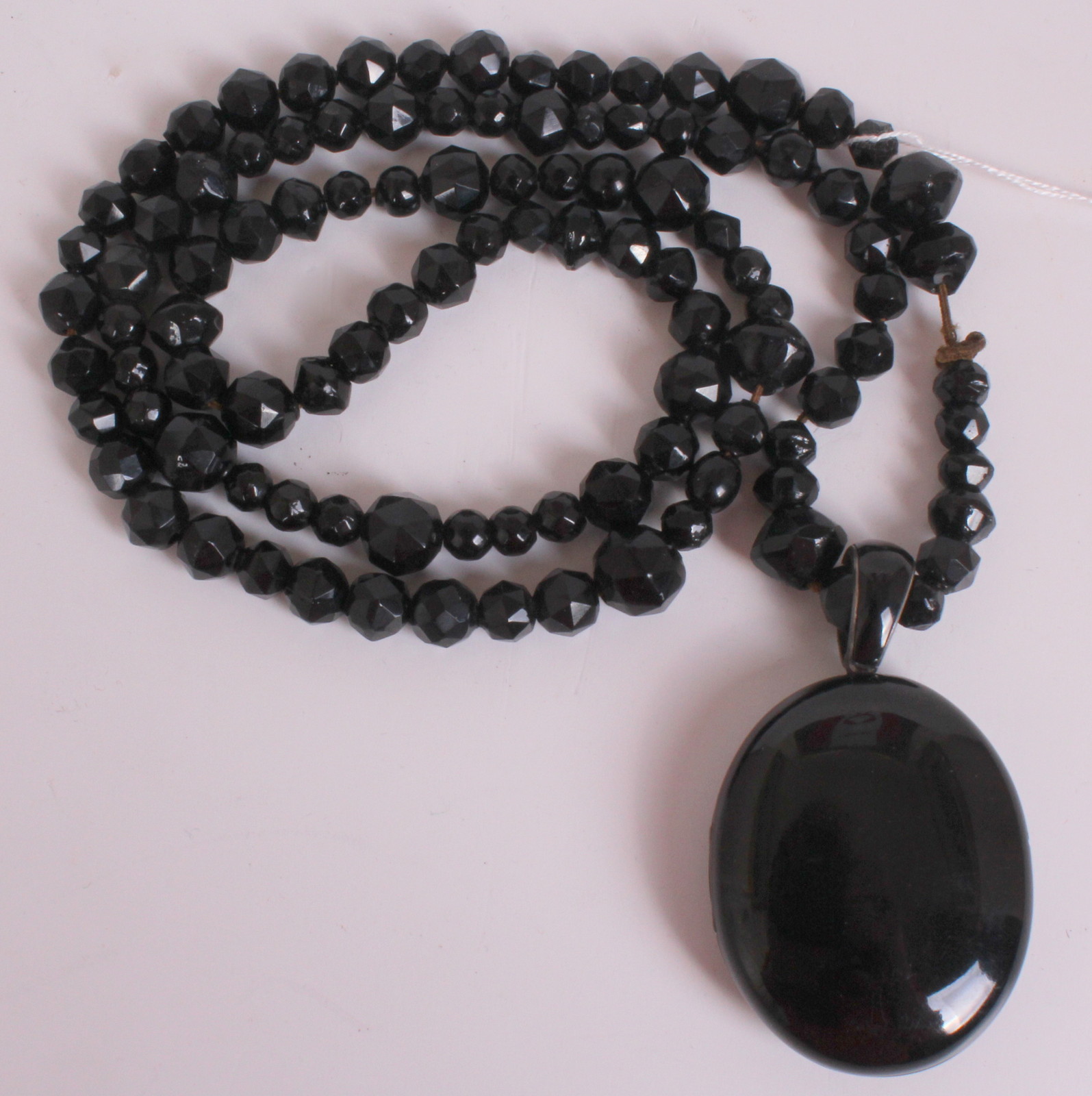 A 1900'S BLACK JET LOCKET With a cut jet bead necklace.