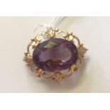 A 20TH CENTURY 9CT GOLD AND AMETHYST BROOCH The central stone mounted with four claws and a