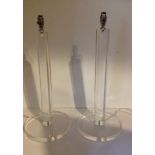 A PAIR OF DESIGNER CLEAR PERSPEX TABLE LAMPS With turned columns, raised on circular platform bases.