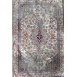 AN IRANIAN SILK RUG WITH CENTRAL MEDALLION  And floral field on a cream ground. 115 x 153cm