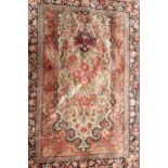 AN IRANIAN SILK PRAYER RUG WITH CENTRAL FLORAL FIELD Contained in running borders, in reds and