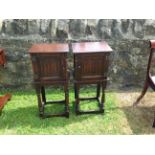 A PAIR OF EARLY 20TH CENTURY OAK BEDSIDE CABINETS With linenfold panelled doors, raised on turned