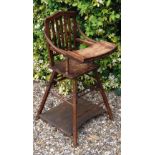 AN EDWARDIAN BEECH WOOD METAMORPHIC CHILD'S CHAIR With hinged front legs and metal wheels.