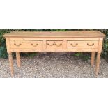 A GEORGIAN PINE DRESSER The short central drawer flanked by two long and raised on turned legs.