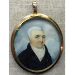 AN 18TH CENTURY OVAL PORTRAIT MINIATURE ON CARD A grey haired gentleman wearing a black overcoat and