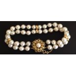 A TWO STRAND CULTURED PEARL BRACELET With 18ct gold clasp (marked '750'), well matched good