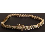 A 14CT GOLD DIAMOND BRACELET SET WITH ROUND CUT DIAMONDS AND EMERALDS Set between 'S' shape links,