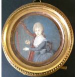 AN 18TH CENTURY FRENCH IVORY PORTRAIT MINIATURE  Of a lady playing a harp, contained in a circular