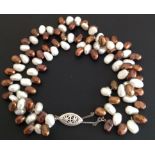 A CULTURED FRESHWATER WHITE AND BROWN PEARL ANKLET Fastened with an almond shaped silver clasp,