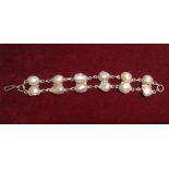 A SILVER AND BAROQUE PEARL BRACELET The six links each formed of two large baroque pearls in