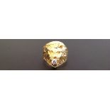 A HEAVY 18CT GOLD RING CAST AS A LION'S HEAD  Holding a solitaire diamond in its mouth (diamond