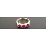 AN 18CT GOLD RING SET WITH THREE OVAL RUBIES DIVIDED BY DIAMONDS (size O) (5851/BG1276405/4)