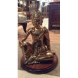 A 20TH CENTURY BRASS STATUE OF A SEATED BUDDHA Converted to an electric lamp on circular wooden