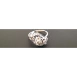 AN 18CT WHITE GOLD AND DIAMOND SET RING The central diamond set within scrolling graduated diamond