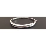 AN 18CT WHITE GOLD AND BAGUETTE CUT DIAMOND HINGED BANGLE  Channel set with baguette cut diamonds