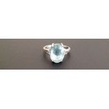 AN 18CT WHITE GOLD DRESS RING SET WITH AN OVAL AQUAMARINE On diamond shoulders (size O/P). (5851/