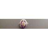 A 9CT GOLD, AMETHYST CABOCHON AND DIAMOND SET RING  The amethyst oval cabochon inset with gold eight